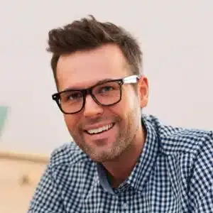 a man wearing glasses and a checkered shirt