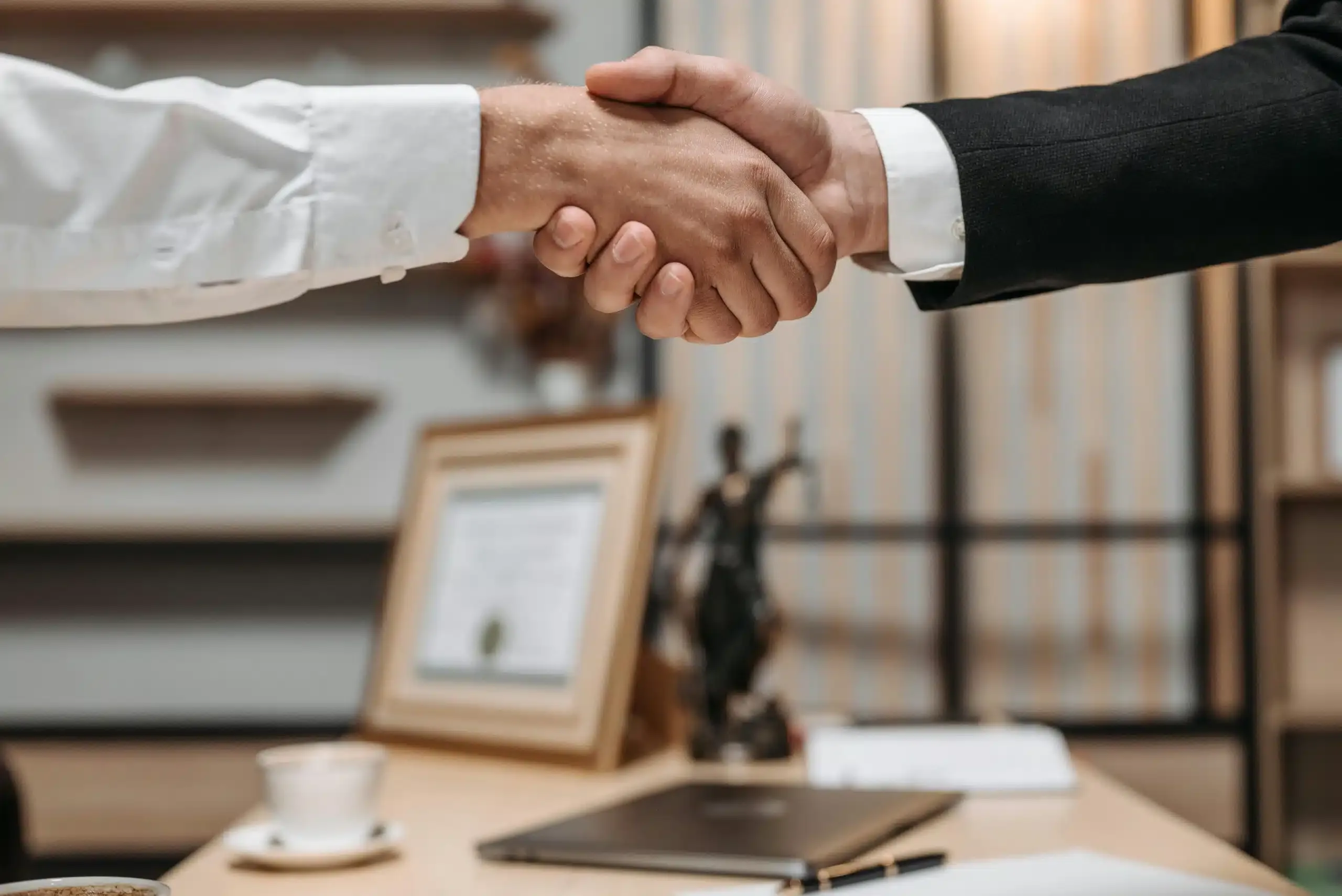 a handshake of people in front of a desk
